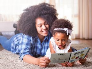 Mother reading Imagination library book to child - UK